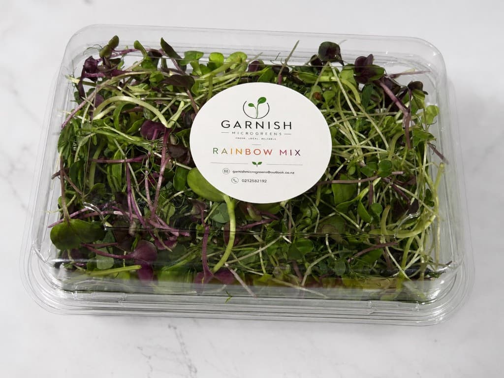 Clamshell pack of Garnish Rainbow Mix microgreens with branded label